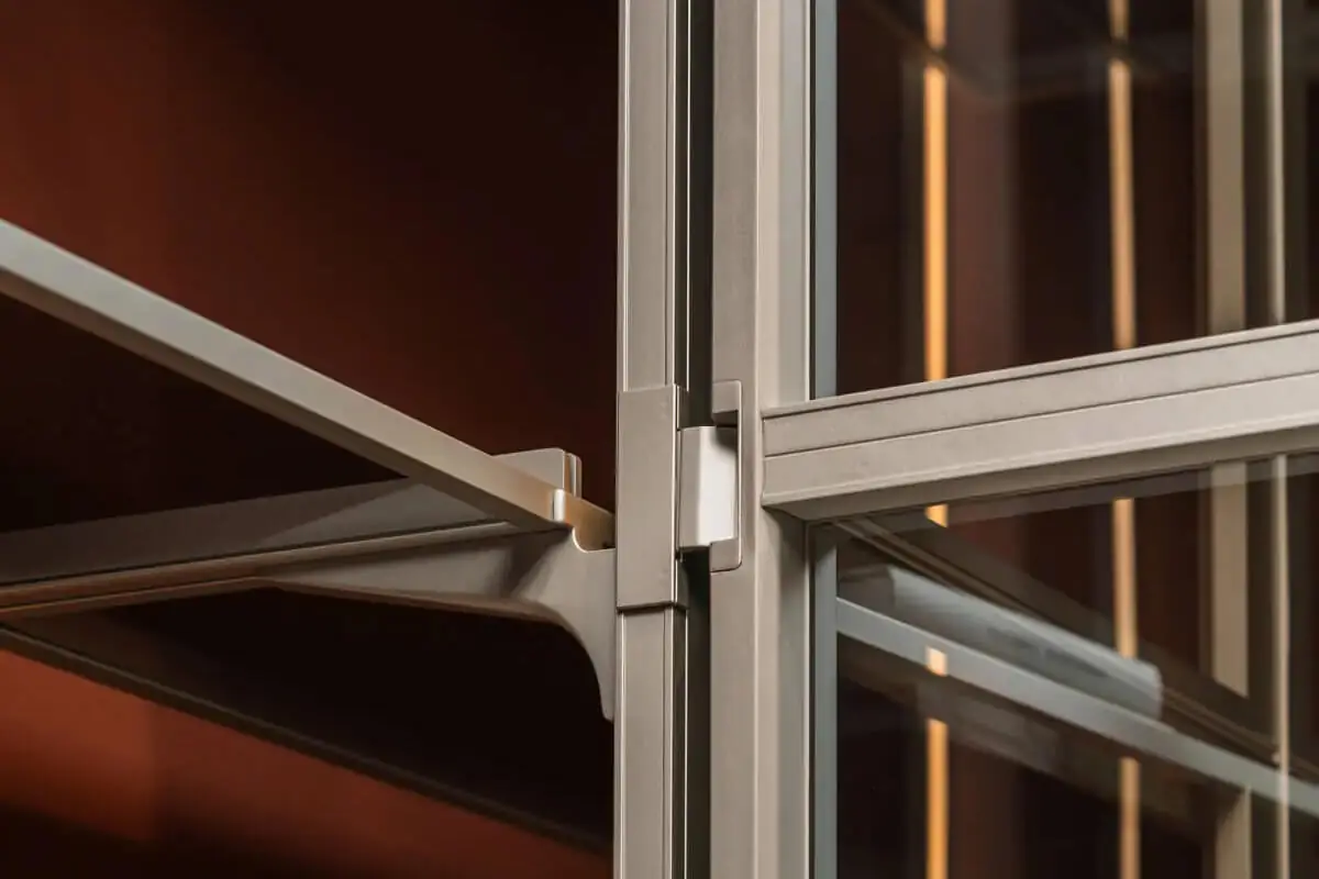 更衣室衣櫃鋁框結構細節近景，金屬層板支架與玻璃門框精密接合，展現義大利步入式衣櫃系統的工藝精準度