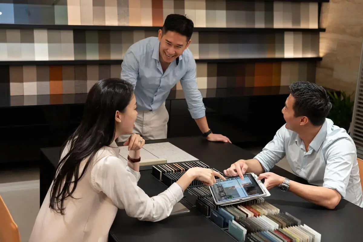 台中進口家具展間顧問與客戶進行一對一空間規劃諮詢，桌面陳列材質樣板，提供義大利家具與台中系統櫃選購建議